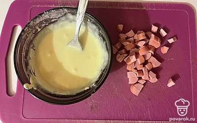 Для теста соедините в миске яйцо, майонез, муку. Сосиску нарежьте мелким кубиком.