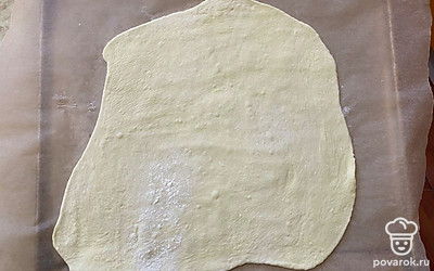 На пергамент выложите раскатанное тесто.