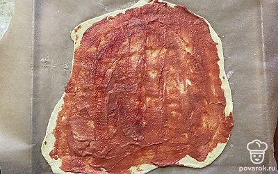 При помощи ложки перемешайте и размажьте соус по всему тесту. 