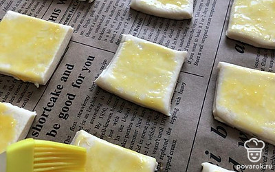 Смажьте каждый квадратик теста яичным желтком. Если есть кунжут, можете им сверху посыпать для красоты. Отправьте тесто в духовку на 5 минут. Следите за корочкой: как только она подрумянится, значит тесто пропеклось.