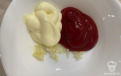 Готовим соус. Для него смешиваем майонез, томатный соус и чеснок.