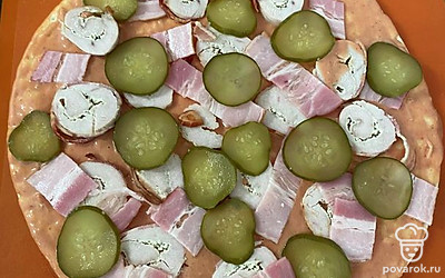 Выкладываем бекон, отварное куриное филе и мелко порезанные огурчики. Отправляем в духовку на 180 градусов.