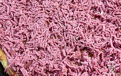 Поверх теста с кетчупом выкладываем колбасу, крупно натертую на терке.