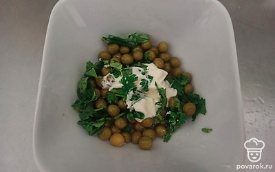 Выложите в соусник консервированный горошек. Добавьте майонез и кинзу, посолите. Помните горошек вилкой и перемешайте получившуюся массу.