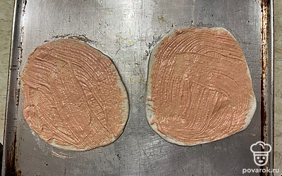 Тесто разделите на две части и раскатайте в тонкий пласт каждую часть, пласты теста перенесите на форму для выпекания и смажьте приготовленным заранее соусом.