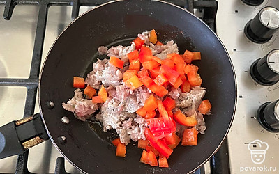 В сковороде соедините оставшееся растительное масло, фарш и нарезанный болгарский перец.
