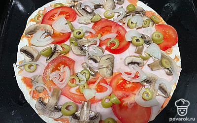 Тонко нарежьте ветчину, помидоры, оливки, грибы и лук. Разложите все ингредиенты на основу для пиццы.