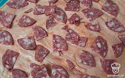 На основу для пиццы добавляем кетчуп и колбасу.