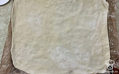 Пласт теста переместите на форму, немного подтягивая края.