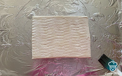 Форму для выпекания смажьте растительным маслом и выложите на нее слоеное тесто.