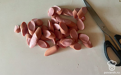 Сосиски нарежьте на небольшие ломтики.