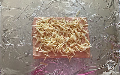 Поверх соуса равномерно распределите половину натертого сыра.