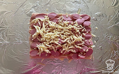 Оставшийся сыр распределите уже поверх сосисок.