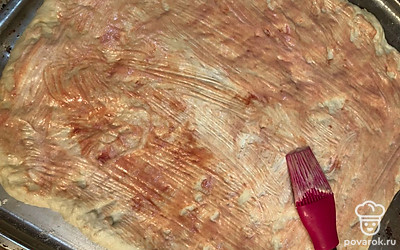 Поднявшееся тесто раскатываем и смазываний майонезом и кетчупом.