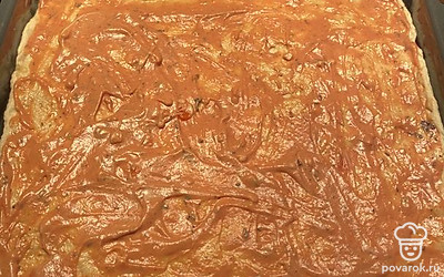 Распределить тесто тонким слоем по противню, смазать соусом.
