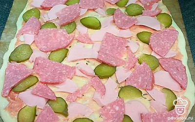Тоненько порежьте огурчик и докторскую и копченую колбасы. Разложите сверху. 
