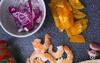 Почистите креветки, нарежьте лук полукольцами, а помидор — дольками.