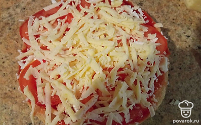 Натрите на терке адыгейский сыр, потом положите нарезанные тоненько круглые кольца помидорки, тертый сыр для пиццы. Добавьте сушеный или свежий базилик.