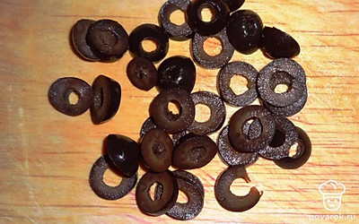 Оливки отцедите от жидкости, обсушите и нарежьте колечками.