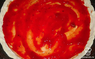 Форму для выпечки смажьте растительным маслом. Выложите тесто, формируя небольшие бортики. Смажьте основу пиццы томатным соусом.