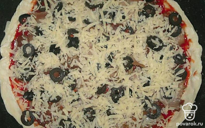 Посыпьте пиццу тёртым сыром. Поставьте форму с пиццей в духовку, разогретую до 220 градусов, на 10-15 минут.