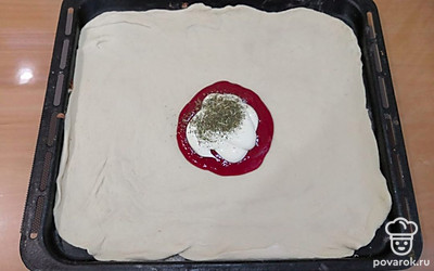 Раскатайте тесто для пиццы желаемой формы, выложите кетчуп, майонез и травы.