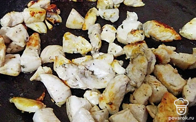 Филе натрите солью, черным молотым перцем и сушеным базиликом по вкусу, затем нарежьте на небольшие кусочки. 3 зубчика чеснока раздавите ножом и отправьте на разогретую сковороду с растительным маслом. Сразу в сковороду добавьте нарезанное филе и обжарьте до золотистого цвета.