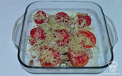 На сырный соус выложите обжаренное куриное филе и разложите по всей поверхности ломтики помидоров. Сверху присыпьте тертым сыром. Форму отправьте в разогретую духовку до 170°C на 20 минут.