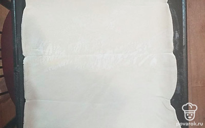 Раскатайте пласт слоеного теста в одном направлении по форме противня