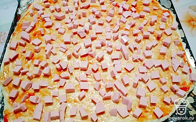 Тесто раскатайте и выложите на противень. Для того чтобы пицца не подгорела, на дно формы тонким слоем посыпьте муку. Смажьте тесто кетчупом или томатной пастой.