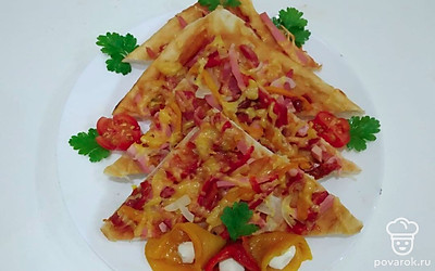 Перед подачей нарежьте пиццу на треугольные кусочки. Украсьте ее зеленью и нарезанными овощами. Также приготовьте к пицце специальный чесночный соус.