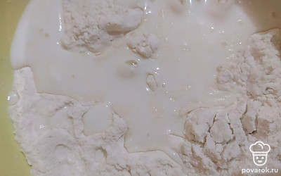 Приступите к приготовлению теста. В миску просейте муку, добив к ней соль, сахар, соду. Добавьте теплый кефир и масло. Перемешайте.