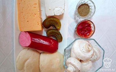 Вытащите тесто для пиццы из упаковки, помойте шампиньоны и разместите на тарелке, оливковое масло и томатную пасту разместите в отдельных емкостях, сыр, огурцы и колбасу разместите на тарелке.