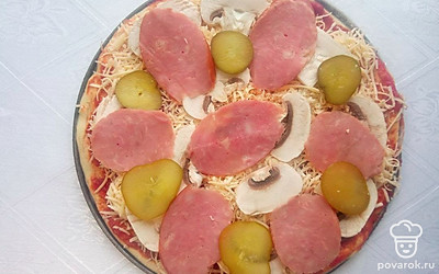 Раскатайте тесто для пиццы, затем смажьте его томатной пастой. Добавьте специи по вкусу, сыр натрите на терке и выложите его на основу для пиццы. Нарежьте шампиньоны и выложите их следующим слоем, потом колбасу нарежьте кружочками, также поступите и с огурцами, это будет завершающий слой в пицце.