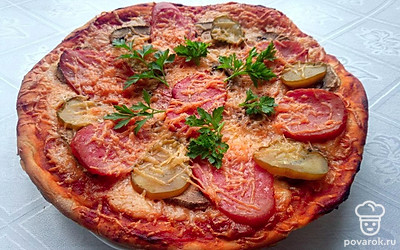 Готовую пиццу посыпьте зеленью.