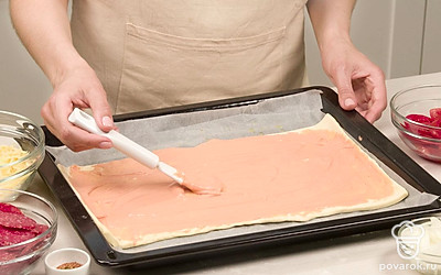 Сделайте основу для пиццы. Размороженное тесто слегка раскатайте или сразу нарежьте на квадраты по 10 см, разложите на противне, смазанном растительным маслом.