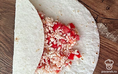 Сверните один край тортильи на начинку, как на фото.