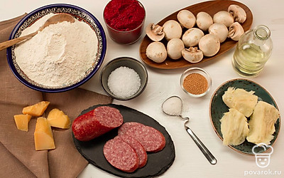 Сыр пармезан натрите на мелкой терке, а моцареллу — на крупной. Нарежьте шампиньоны и салями слайсами. Подогрейте воду. Разогрейте духовку до 220°C.