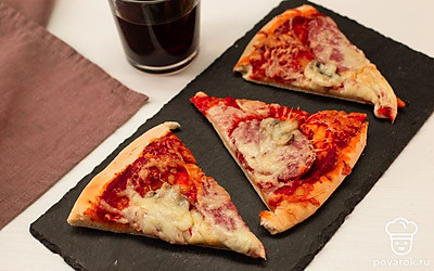 Когда тесто подрумянится до золотой корочки, достаньте пиццу и нарежьте кусочками.