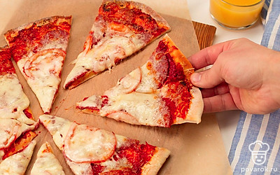 Приготовленную пиццу нарежьте кусочками и подавайте.