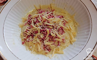 Выложите нарезанную тонкой соломкой копченую колбасу и тертый на крупной терке сыр. Тщательно перемешайте. 