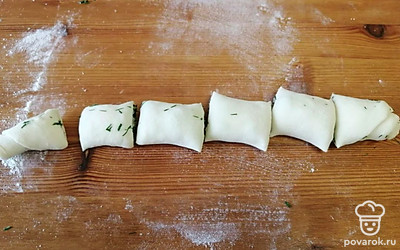 Сверните тесто рулетом и нарежьте небольшими кусочками.