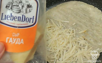 Лепешку обжарьте с одной стороны, переверните. Выложите на одну сторону тертый сыр.