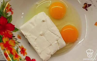 Творог выложите в миску и вбейте яйца. 