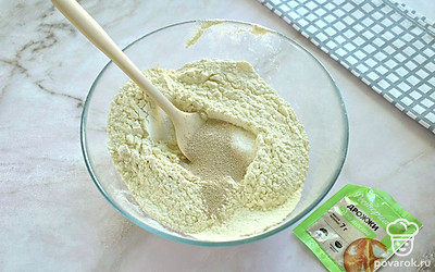 Просейте в глубокую миску пшеничную муку. Всыпьте в муку сахар, соль и сухие быстродействующие дрожжи. Лопаточкой или ложкой перемешайте сыпучие ингредиенты. 
