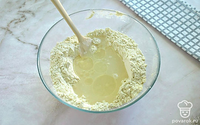 В получившуюся мучную смесь влейте теплую воду и растительное масло. 