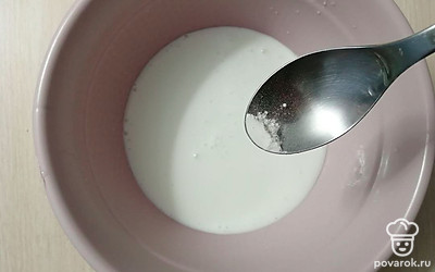 В глубокую миску налейте 100 миллилитров теплого кефира, добавьте разрыхлитель теста.