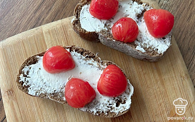 Снимите с помидоров кожицу и разрежьте пополам. Выложите на чиабатту.