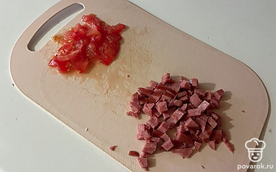 Помидор и колбасу нарежьте мелким кубиком.
