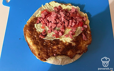 На 1/2 часть лепешки выложите начинку из салата, помидора и колбасы.